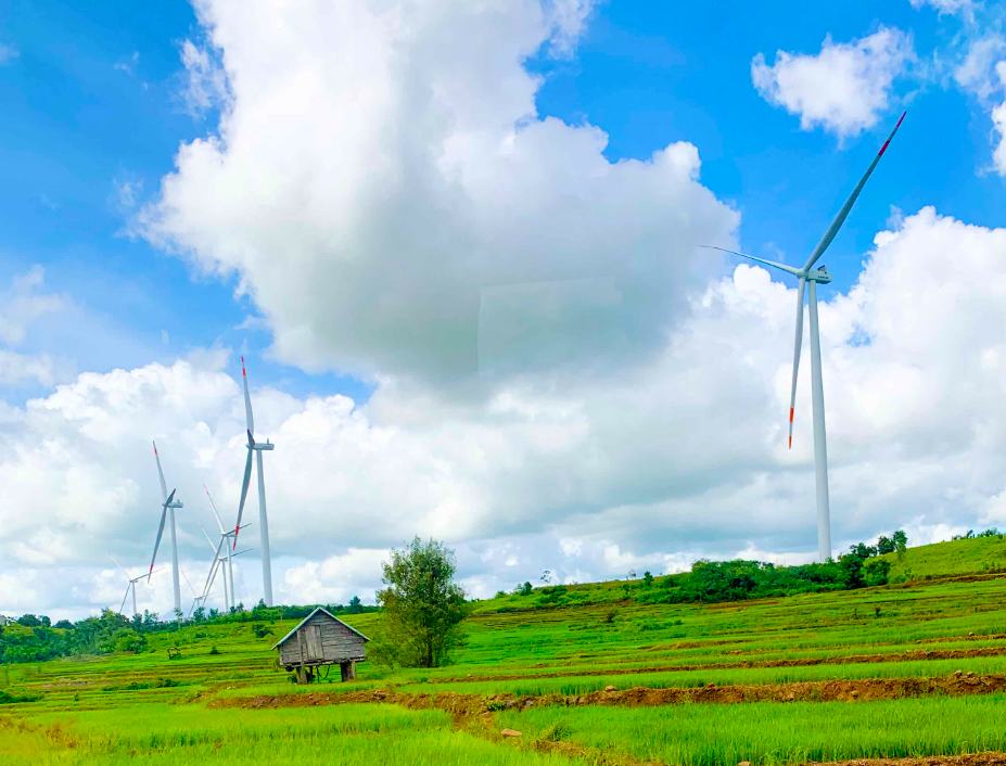 Onshore wind turbines rising above terraced green farmland